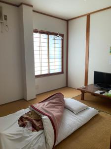 Cette chambre comprend un lit et une table. dans l'établissement 民宿ニュー万福茶屋, à Taketa