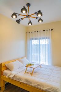 a bedroom with a bed with a ceiling fan and a window at 2 bedroom at Bristle Ridge in Baguio