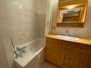 La salle de bains est pourvue d'un lavabo, d'une baignoire et d'un miroir. dans l'établissement Appartement Le Grand-Bornand, 3 pièces, 6 personnes - FR-1-241-236, au Grand-Bornand