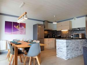 a dining room and kitchen with a wooden table and chairs at "Superbe Appartement 8/10 pers, 105m², Centre Station, Accès Direct Pistes" - FR-1-545-22 in Val Thorens