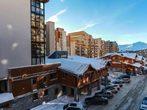 a snow covered city with buildings and cars parked at "Superbe Appartement 8/10 pers, 105m², Centre Station, Accès Direct Pistes" - FR-1-545-22 in Val Thorens