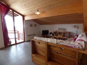 a living room with a bed in a wooden room at Appartement Le Grand-Bornand, 4 pièces, 8 personnes - FR-1-458-147 in Le Grand-Bornand