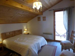 a bedroom with a large bed and a large window at Appartement Le Grand-Bornand, 4 pièces, 8 personnes - FR-1-458-147 in Le Grand-Bornand