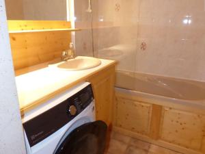 een badkamer met een wastafel en een wasmachine bij Appartement Le Grand-Bornand, 2 pièces, 4 personnes - FR-1-458-161 in Le Grand-Bornand