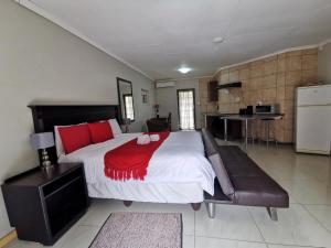 een slaapkamer met een groot bed met rode kussens bij The Catwalk Lodge in Pretoria