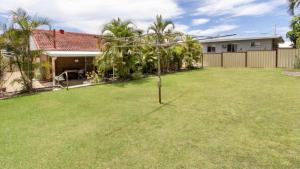 a small tree in the yard of a house at Comfortable lowset family home only minutes from the water! Tarooki St, Bellara in Bellara
