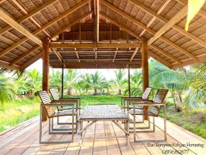 a group of chairs and a table on a deck at Bang Mee Homestay Koh Yao Noi in Ko Yao Noi