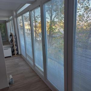 a room with large windows with blinds on them at Lovely 1- bedroom condo close to downtown in Skopje