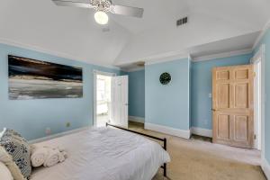 グリーンズボロにあるThe Magnolia Manor - Private Backyard - Close to Downtownの青い壁のベッドルーム1室、天井ファン付きのベッド1台が備わります。