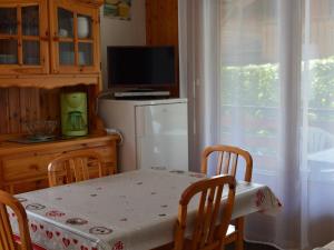 a kitchen with a table and a refrigerator and a television at Appartement Le Grand-Bornand, 2 pièces, 6 personnes - FR-1-241-212 in Le Grand-Bornand