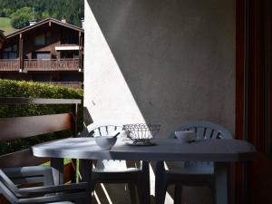 a white table and chairs on a balcony with a table and chairs at Appartement Le Grand-Bornand, 2 pièces, 6 personnes - FR-1-241-212 in Le Grand-Bornand