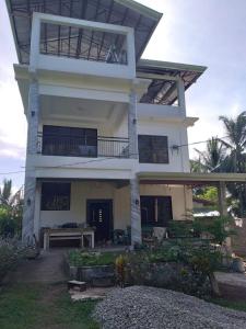 a large white house with a porch and a balcony at Taylor's Country Home- The Grande by Taylor's Traveller's Inn Second Floor in Catarman