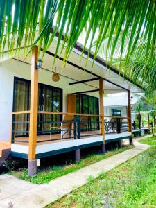 a house with a palm tree in front of it at Bang Mee Homestay Koh Yao Noi in Ko Yao Noi