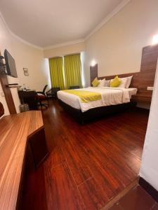Habitación de hotel con cama y suelo de madera. en Hotel Presidency, en Kochi