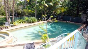 a large swimming pool with a white fence and trees at Burleigh Terraces - Hosted by Burleigh Letting in Gold Coast