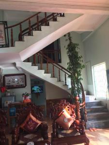 uma escada numa sala de estar com um sofá e escadas em Nhà Nghỉ Bình Dân Xanh em Bắc Quang