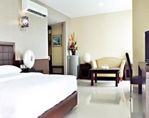 Habitación de hotel con cama, mesa y sillas en BAMBOO INN HOTEL & CAFE, en Yakarta