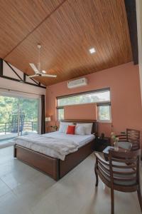 a bedroom with a bed and a wooden ceiling at SaffronStays Wildernest, Dehradun - pet-friendly Swedish home amidst nature in Dehradun