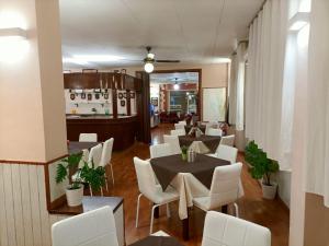 a restaurant with white chairs and tables in a room at Giappone Inn Parking Hotel in Livorno