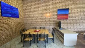 a restaurant with a table and chairs and paintings on the wall at Puggle Palace, 21A Bower Street in Jurien Bay +5 photos