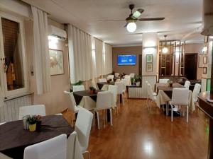 a dining room with tables and white chairs at Giappone Inn Parking Hotel in Livorno