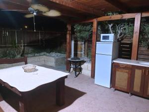 an outdoor kitchen with a table and a white refrigerator at viktoryadream in Eilat