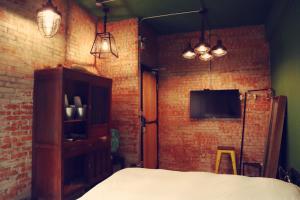 a bedroom with a bed and two lights and a tv at Travel Charger Hostel in Hualien City