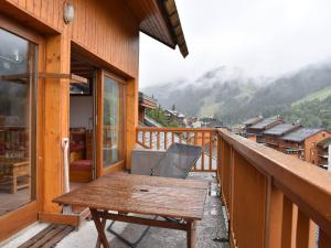 Les AlluesにあるCharmant 2 pièces mezzanine, 6 pers, centre Méribel, proche pistes et commerces - FR-1-180-364の木製ポーチ(木製テーブル付)