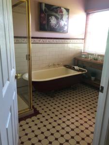 a bathroom with a tub and a tiled floor at Sea Change Guesthouse in Apollo Bay