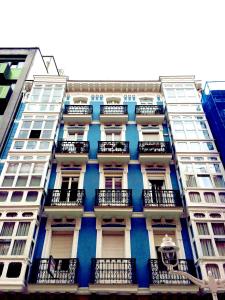 un edificio alto con balcones a un lado. en Pension Martinez, en Bilbao
