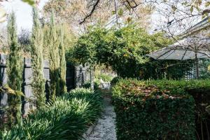 a garden with a fence and a path with plants at Carrington House Daylesford in Daylesford