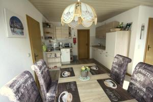 eine Küche und ein Esszimmer mit einem Tisch und Stühlen in der Unterkunft Ferienwohnung Panoramablick in Neudorf