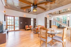 德拉敦SaffronStays Polaris, Dehradun - pet-friendly Swedish home amidst nature的一间带桌椅的客厅和一间用餐室