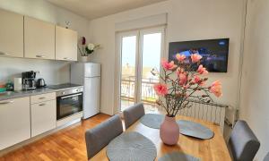 a kitchen with a table with a vase of flowers on it at Bellevue in Izola