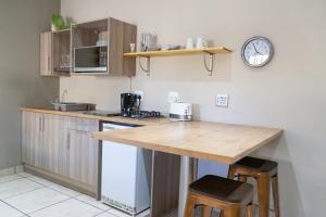 a kitchen with a wooden counter top in a room at De Akker Guest House Oudtshoorn in Oudtshoorn