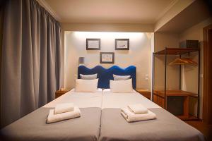 ein Schlafzimmer mit einem großen Bett mit zwei Handtüchern darauf in der Unterkunft FALIREON HOTEL in Athen