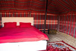 Muntaribにあるwahiba Bedouiens privae Campの赤い壁のベッドルーム1室