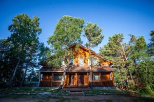 a log cabin in the woods with trees at Baikalskaya Riviera Hotel in Gremyachinsk
