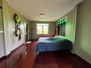 een slaapkamer met een bed in het midden van een kamer bij BanLomLak in Sukhothai
