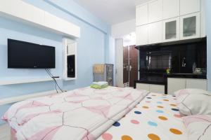 1 dormitorio con 1 cama grande y TV en la pared en Kapuk City Cengkareng, en Yakarta