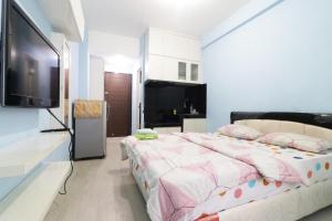 Kapuk City Cengkareng في جاكرتا: غرفة نوم بسرير وتلفزيون بشاشة مسطحة