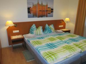 Bett in einem Zimmer mit zwei Lampen und einem Bild an der Wand in der Unterkunft Pension Weinhaus Unger in Schwenningen