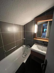 uma casa de banho com uma banheira e um lavatório em Superbe Appartement à Montchavin em Montchavin