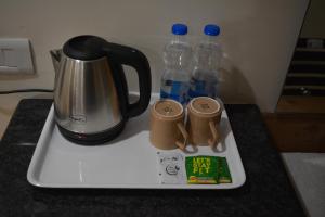 a tray with two bottles of water and a kettle at Hotel Ambicas Grand in Visakhapatnam