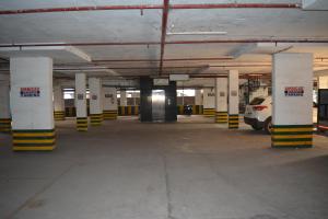 an empty parking garage with a car parked in it at Hotel Ambicas Grand in Visakhapatnam