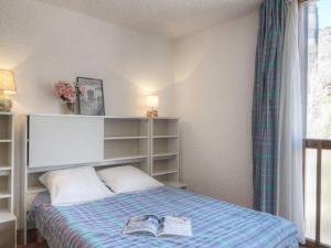 - une chambre avec un lit et un livre dans l'établissement Appartement Saint-Chaffrey , 2 pièces, 6 personnes - FR-1-330E-28, à Saint-Chaffrey