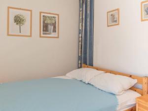 a bed in a bedroom with two pictures on the wall at Appartement lumineux 2 pièces 6 pers, proche pistes et commerces - La Salle Les Alpes - FR-1-330F-29 in Serre Chevalier