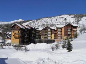 a large building in the snow with a mountain at Appartement Saint-Chaffrey , 3 pièces, 6 personnes - FR-1-330E-21 in Saint-Chaffrey