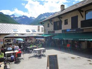 eine Gruppe von Menschen, die an Tischen vor einem Gebäude sitzen in der Unterkunft Charmant T2 avec coin montagne, 6 couchages, Monêtier les Bains, proche commerces et navettes ski - FR-1-330F-35 in Le Monêtier-les-Bains