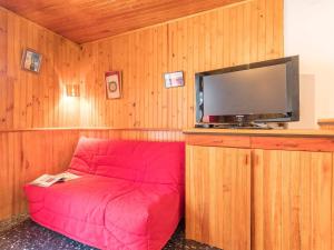 セレ・シュヴァリエにあるAppartement Serre Chevalier, 2 pièces, 4 personnes - FR-1-330F-37の薄型テレビ付きの客室で、赤いソファが備わります。